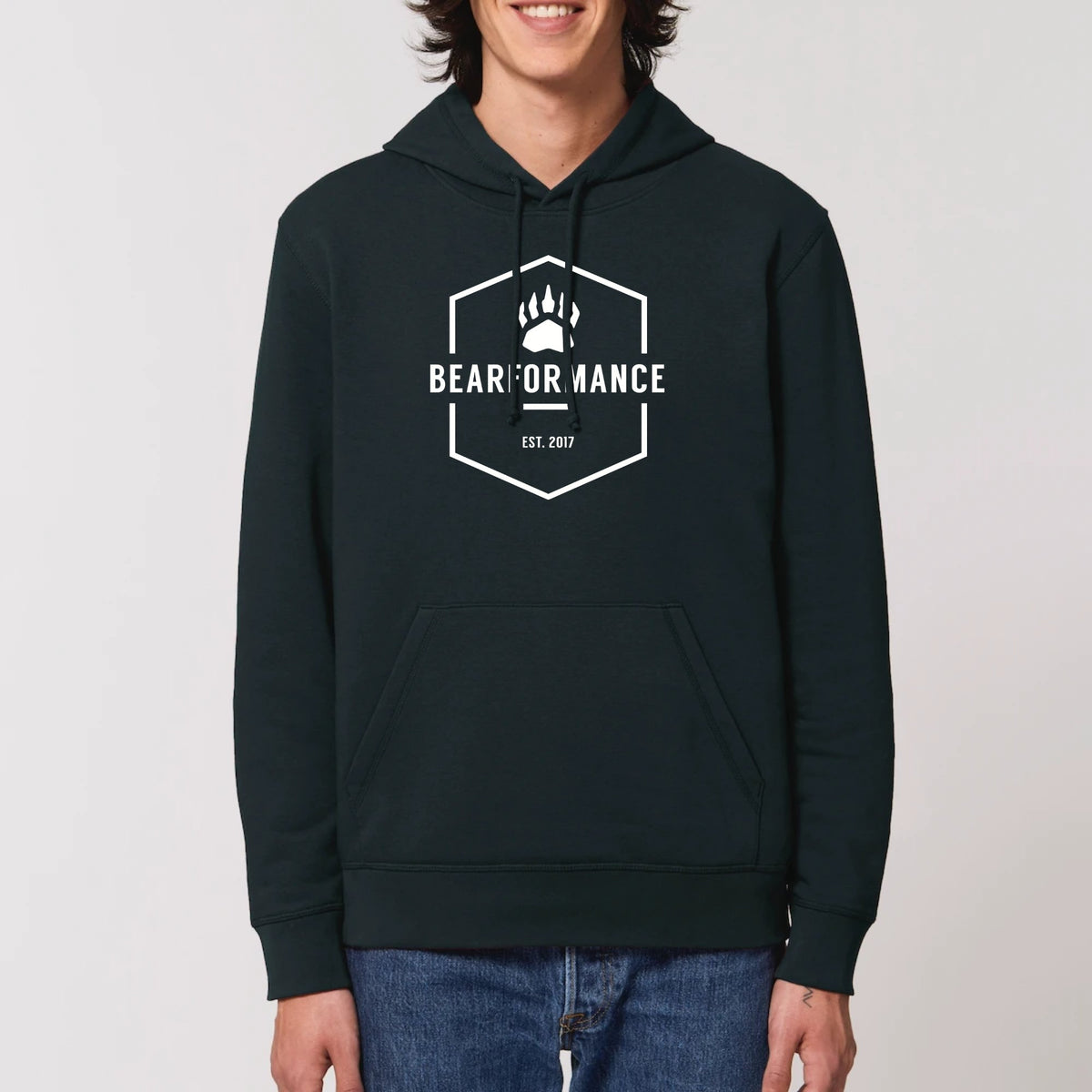 Mann trägt schwarzen BEARFORMANCE Unisex Hoodie aus Bio-Baumwolle mit weißem Logo-Emblem