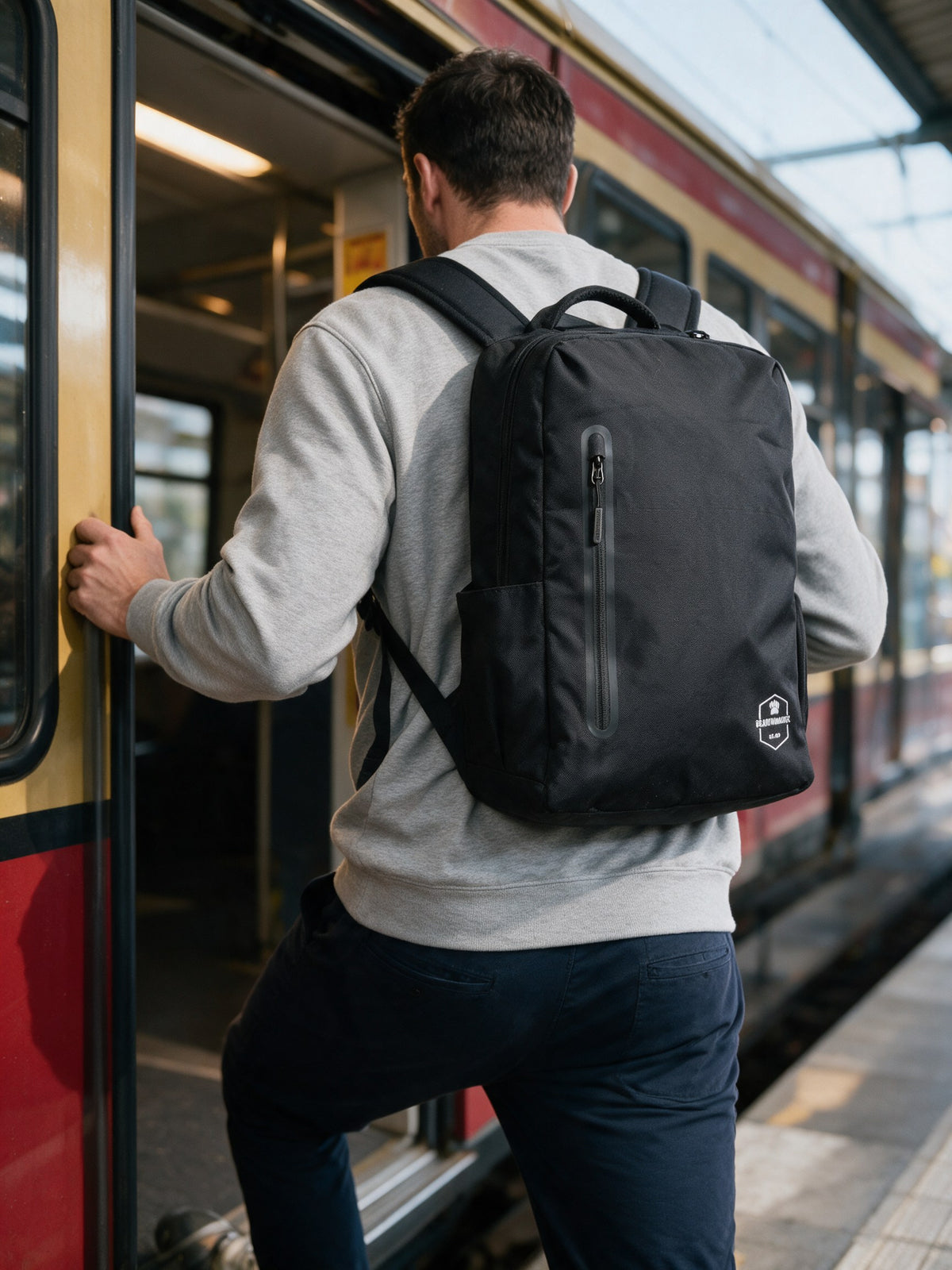 Mann mit dem Bearformance Daypack auf dem Rücken beim Einstieg in die S-Bahn – Pendler-Rucksack mit gepolstertem Laptopfach