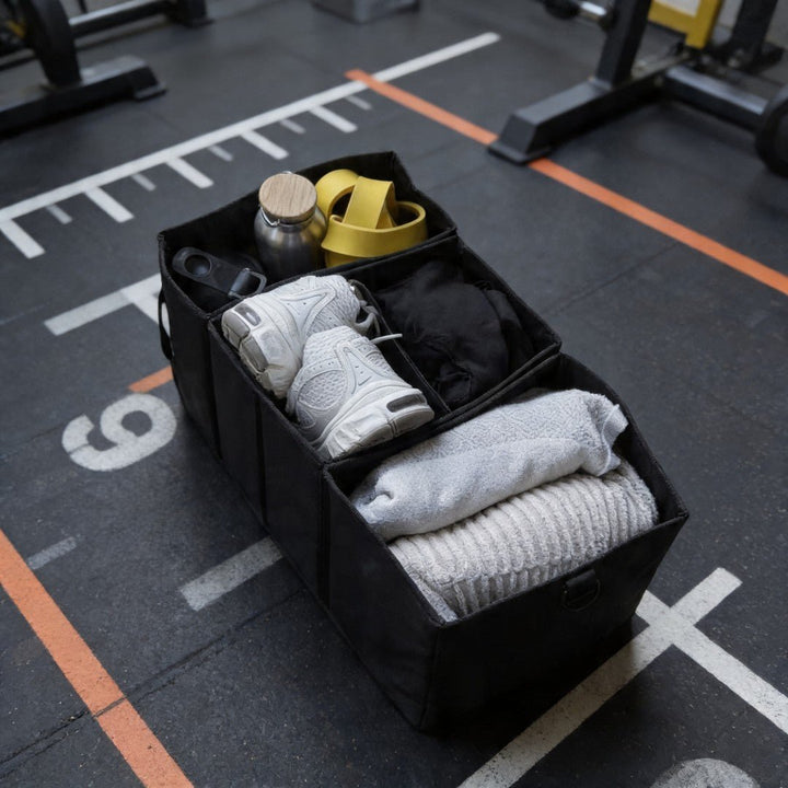 BEARFORMANCE Divider in Schwarz auf dem Gym-Boden, gepackt mit Sneakern, Handtüchern und Trinkflasche – Ordnungssystem mit drei Fächern