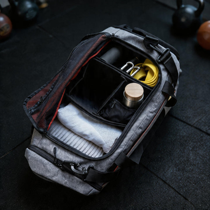 Divider eingesetzt in der geöffneten grauen Ultimate Sportbag – unterteilt die Sporttasche in Fächer für Flasche, Handtuch und Ausrüstung